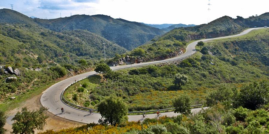 Radfahrer fahren die kurvenreiche Bergstraße hinauf zu Penas Blancas in der Nähe von Estepona